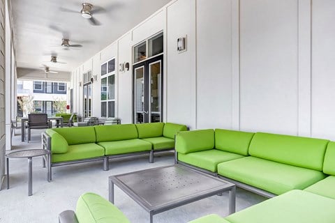 a living room with green couches and a table