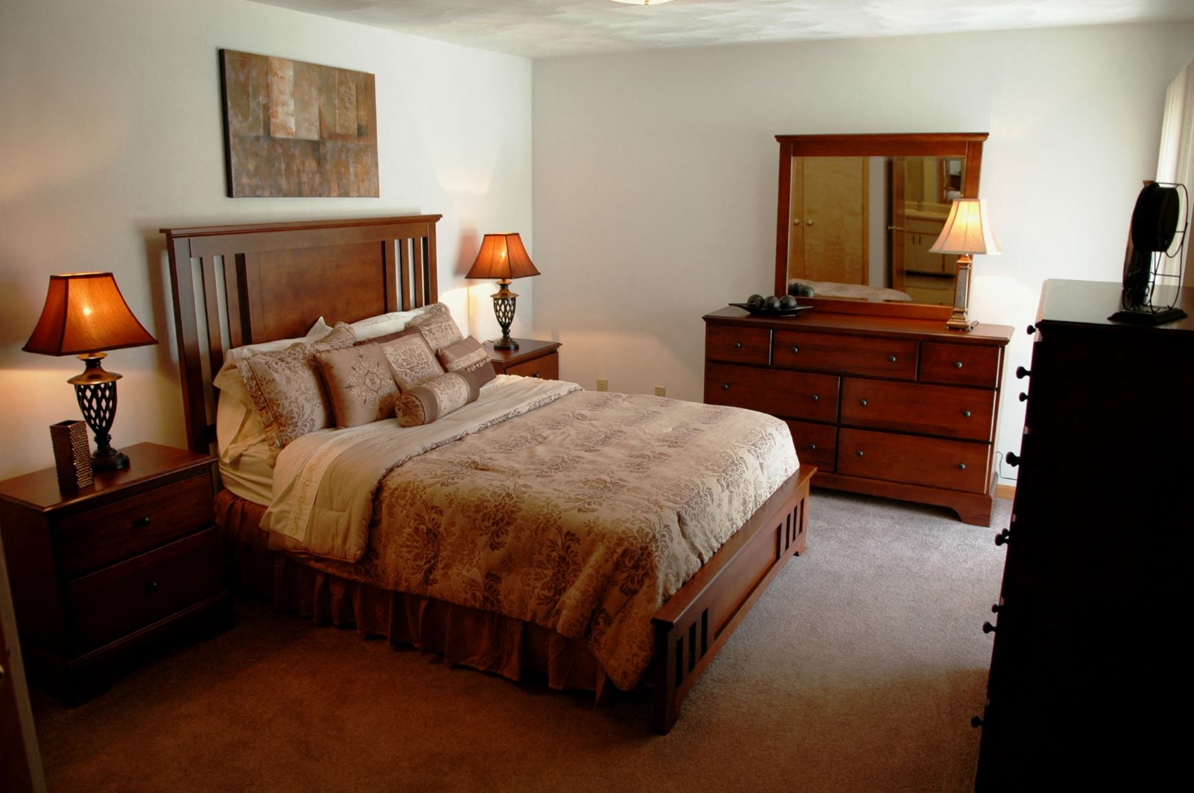 a bedroom with a bed and dressers and a mirror