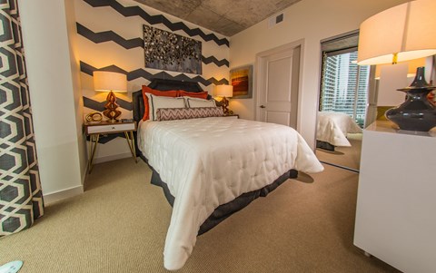 A bedroom with a large bed and a painting on the wall.