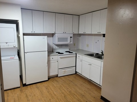A kitchen with white appliances and cabinets.