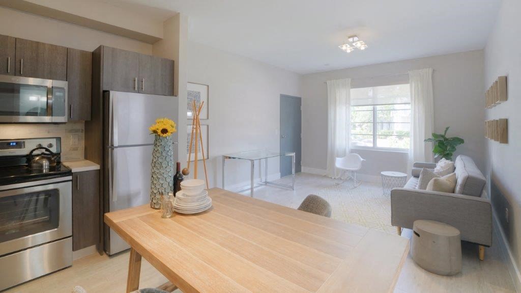 a kitchen and living room with a wooden table