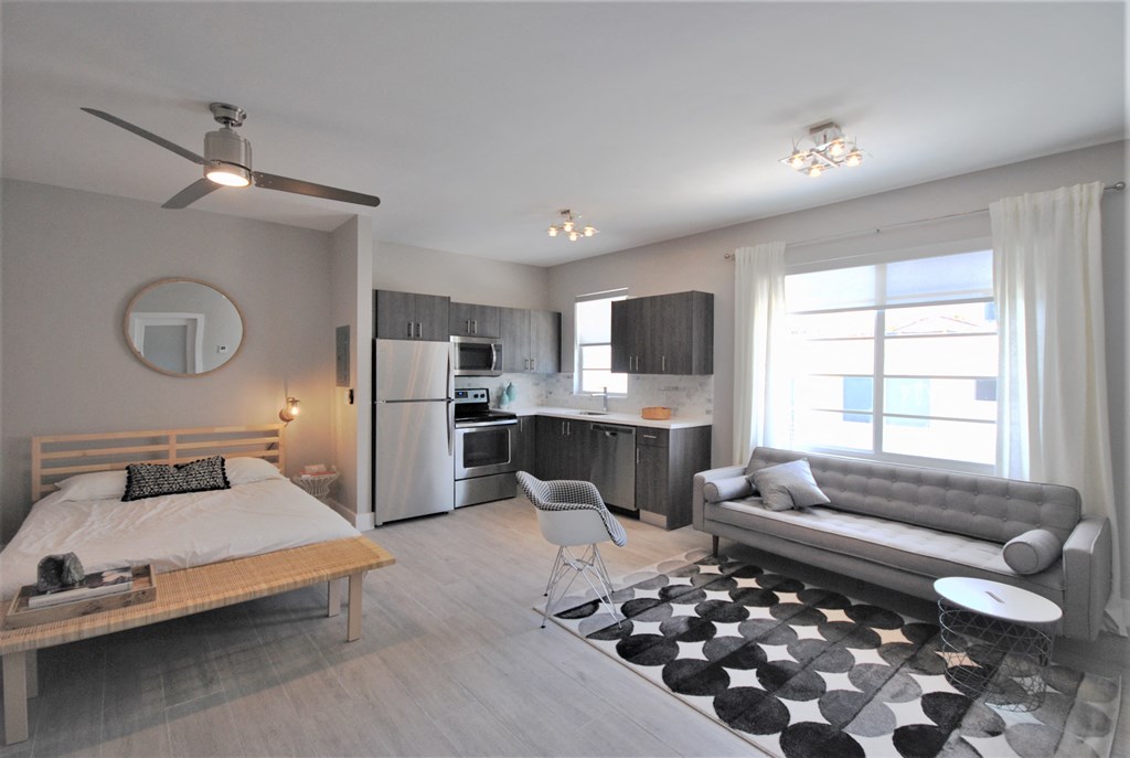 a bedroom with a bed and a living room with a kitchen