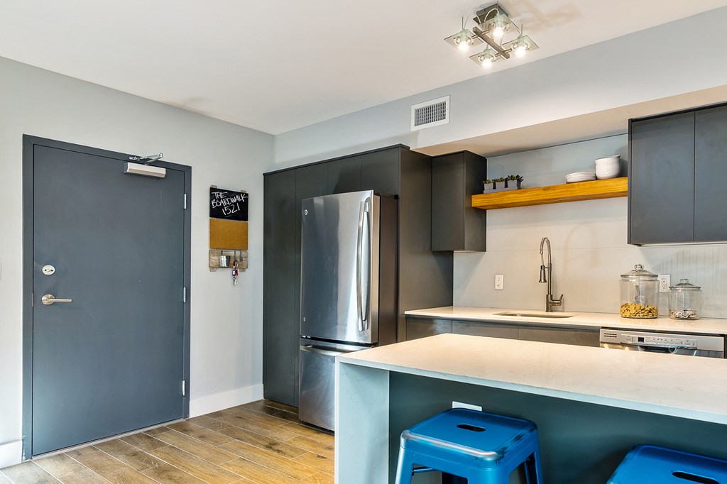 a kitchen with stainless steel appliances and blue stools