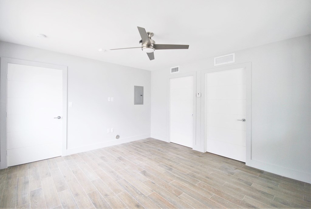 an empty room with white walls and a ceiling fan