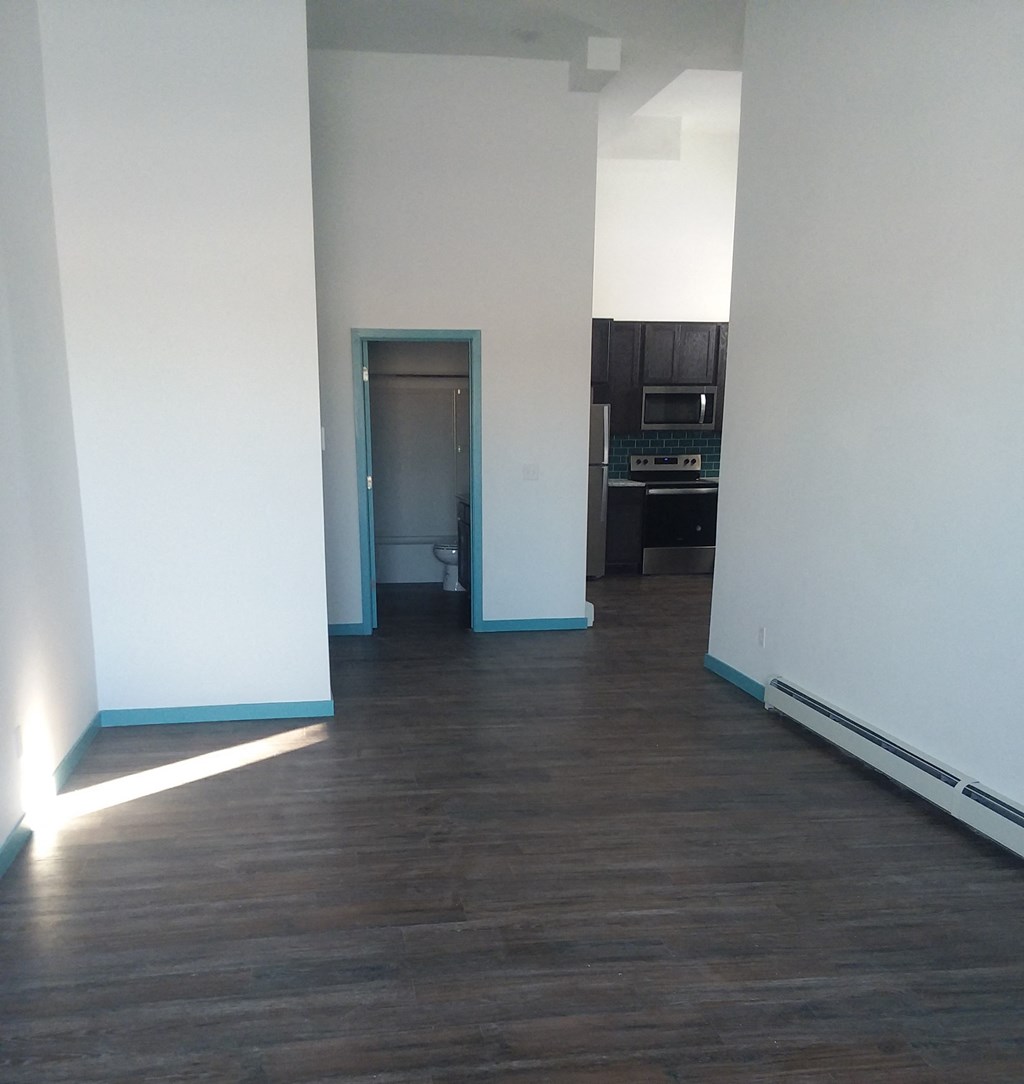 an empty room with a hard wood floor and white walls