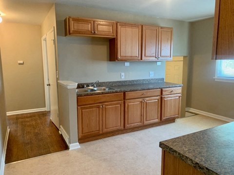 A kitchen with wooden cabinets and a granite countertop.