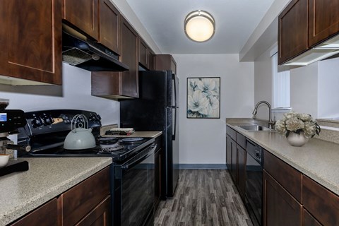 full kitchen with black appliances and granite counter tops with wood cabinets