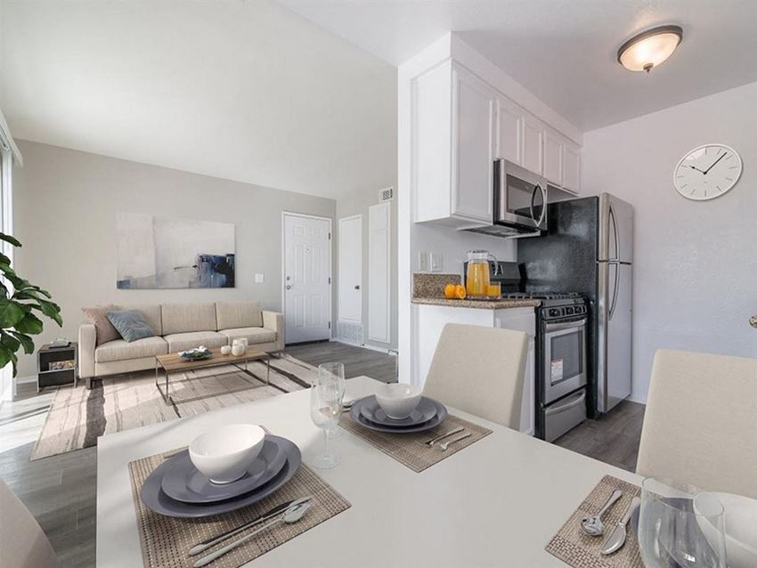 a kitchen and living room with a table and chairs