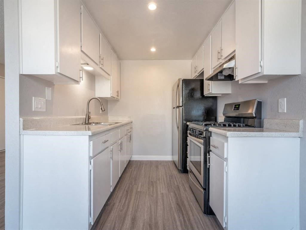 a kitchen with white cabinets and a stove and a refrigerator