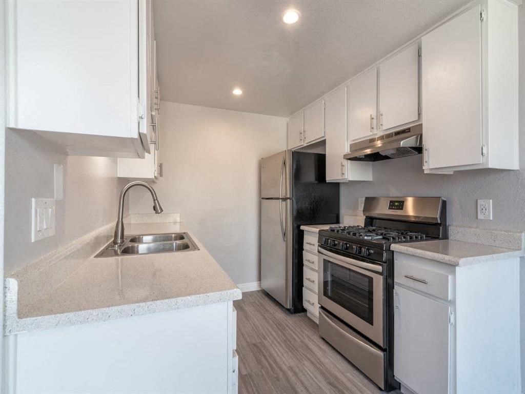 a kitchen with a sink and a stove and a refrigerator