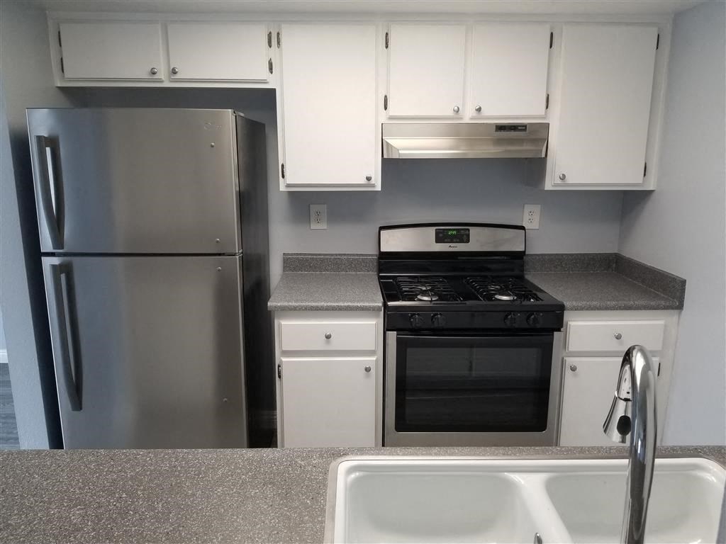 a kitchen with stainless steel appliances and white cabinets