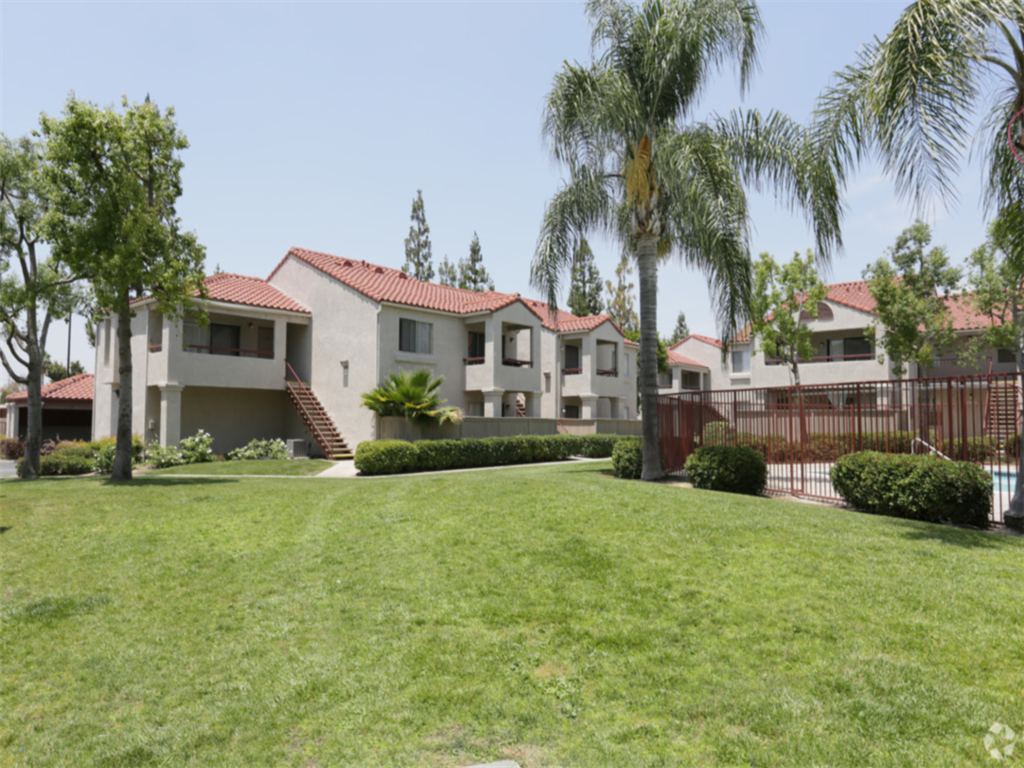 a group of houses with a yard and palm trees