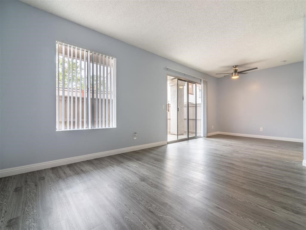 an empty living room with wood floors and a window