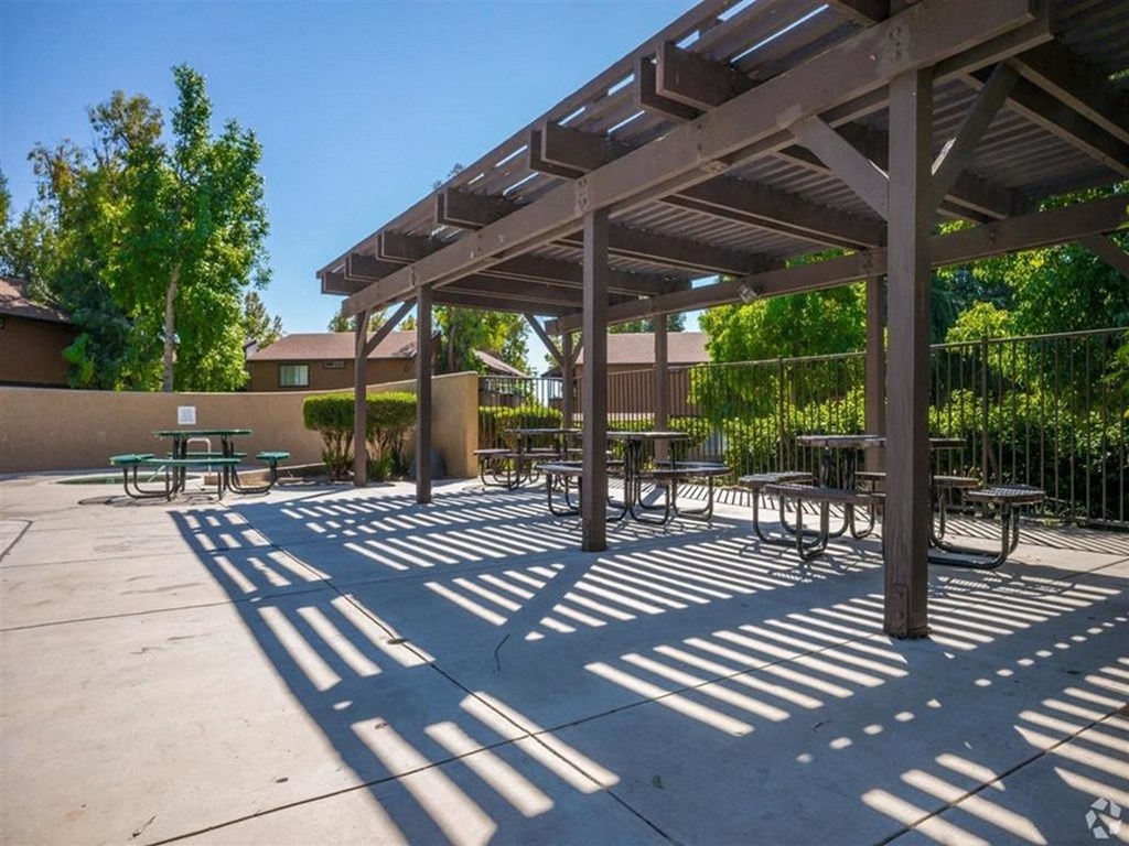 a picnic area with benches and tables under awning
