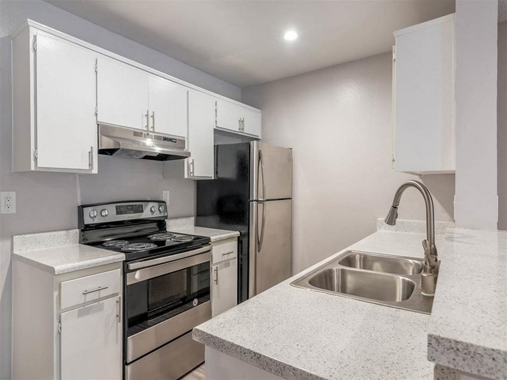 a kitchen with white cabinets and stainless steel appliances