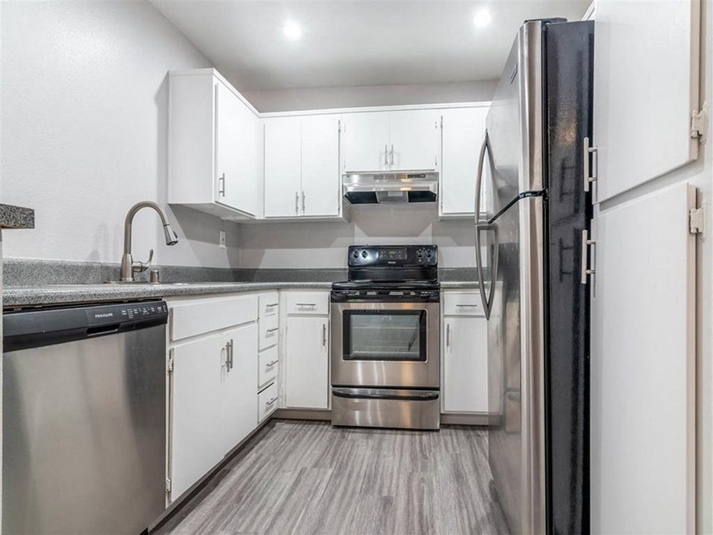 a kitchen with white cabinets and stainless steel appliances