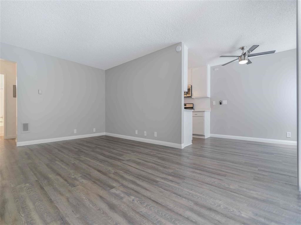 an empty living room with white walls and wood floors