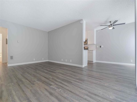 an empty living room with white walls and wood floors
