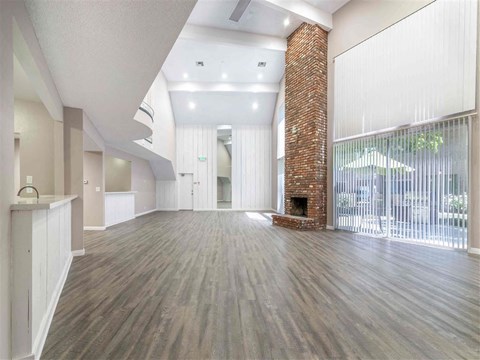 an open living room with a fireplace and wood flooring