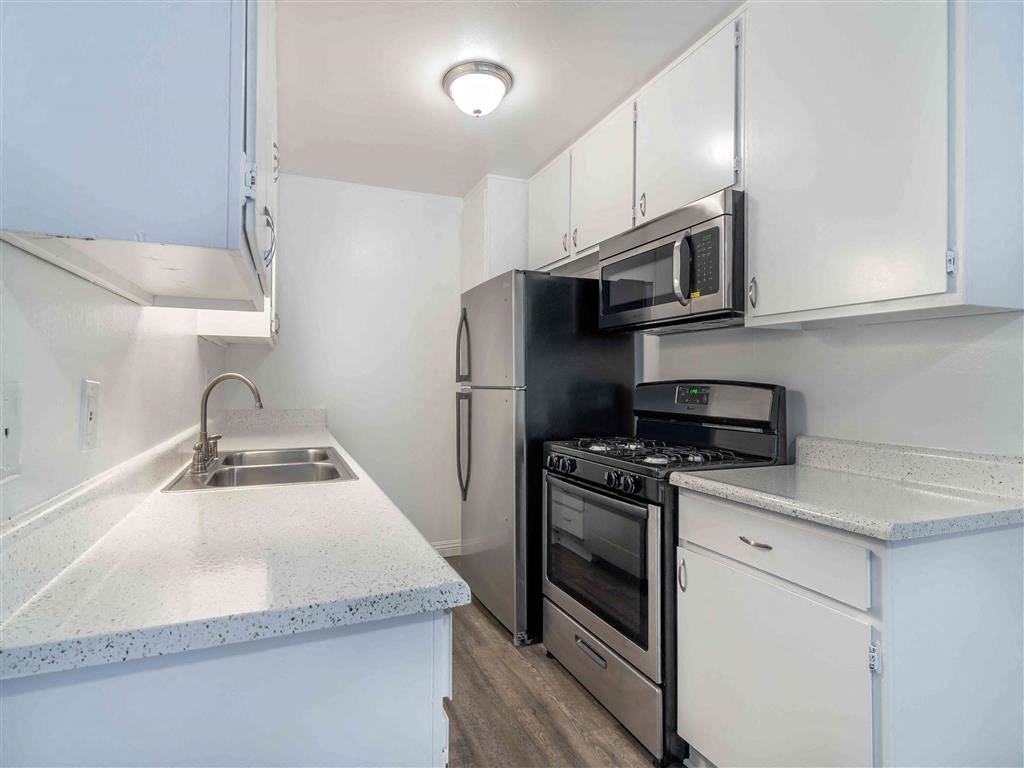 a kitchen with a sink and a stove and a microwave