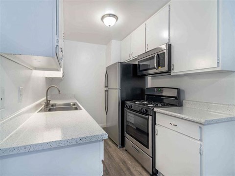 a kitchen with a sink and a stove and a microwave