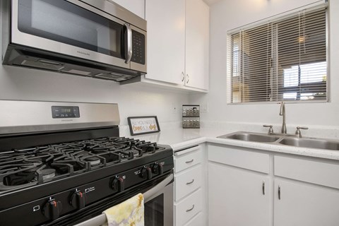 a kitchen with a stove and a sink and a microwave