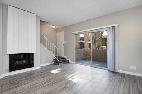 the living room has a fireplace and a sliding glass door to the patio