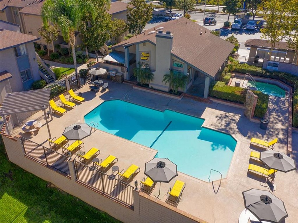 swimming pool with yellow chairs and umbrellas around it