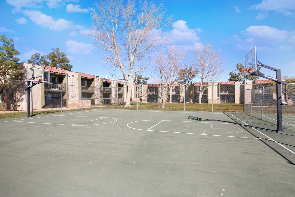 an empty basketball court in front of a building