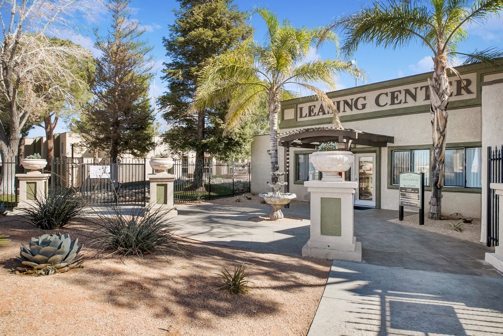 the leasing center building with palm trees and a fountain