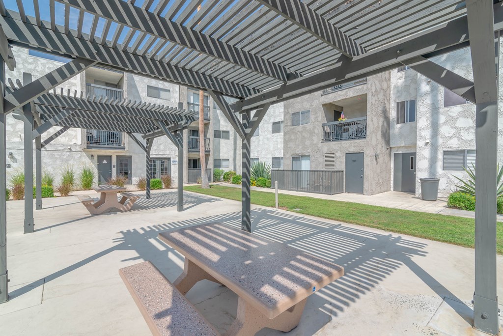 a picnic table sits under awnings in a courtyard