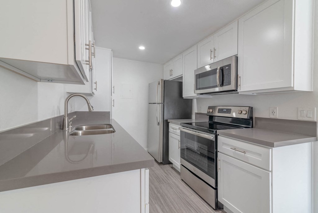 a kitchen with white cabinets and stainless steel appliances