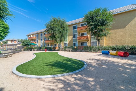 a courtyard with a small patch of grass in front of an apartment building