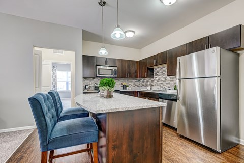 a kitchen with stainless steel appliances and a marble counter top
