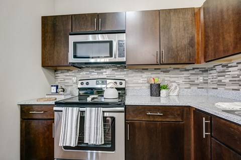 a kitchen with a stove and microwave and wooden cabinets