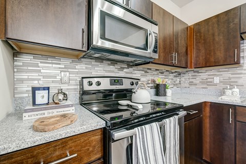 a kitchen with a stove and microwave and wooden cabinets
