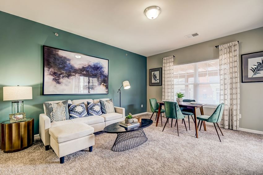 a living room with green walls and a couch and a table with chairs