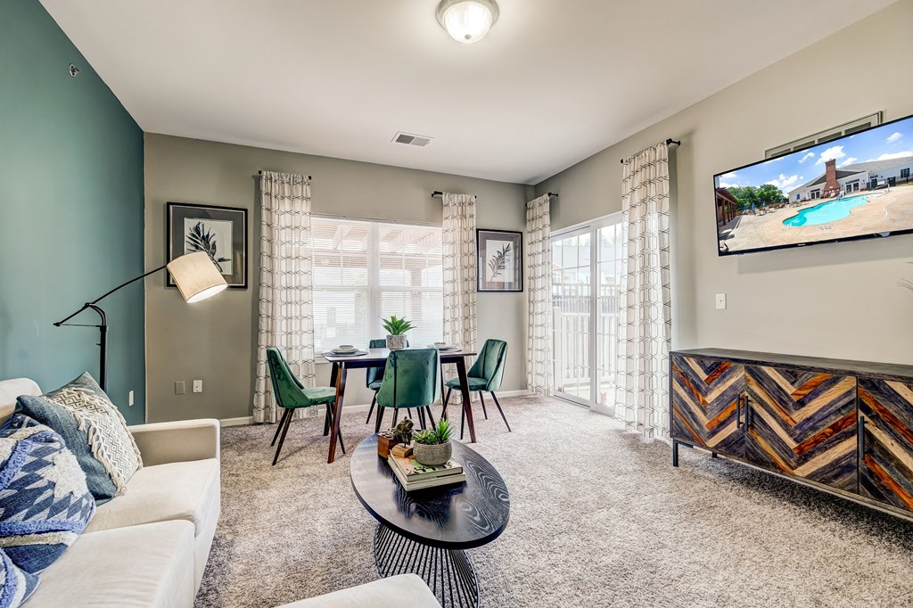 a living room with a couch and a table with chairs and a tv