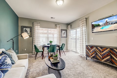 a living room with a couch and a table with chairs and a tv