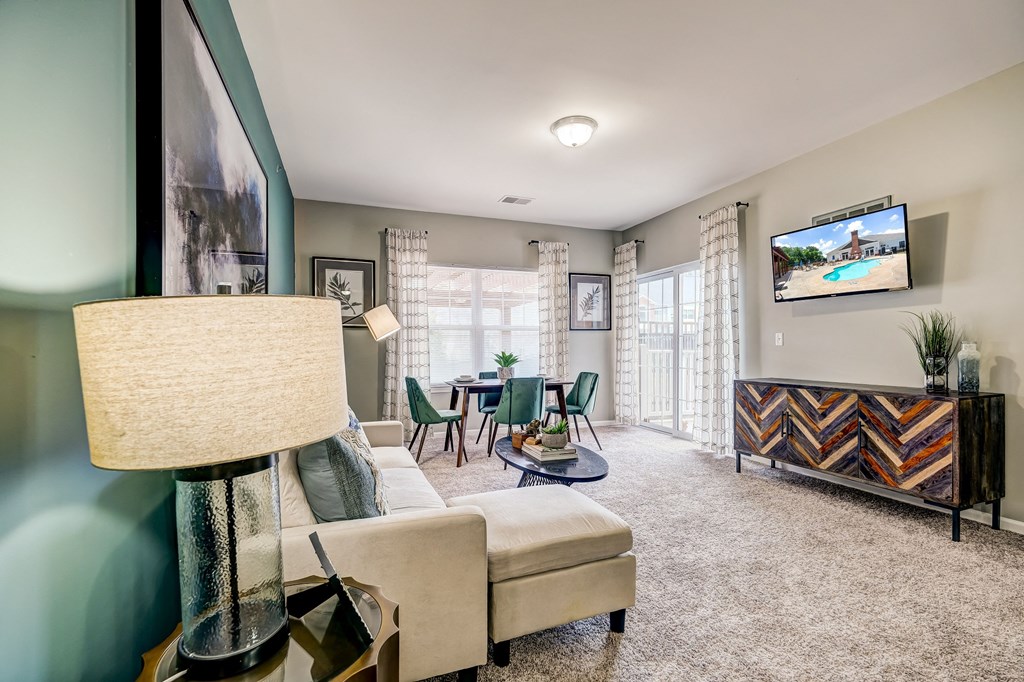 a living room with a couch and a table with chairs and a tv