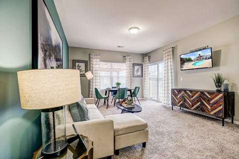 a living room with a couch and a table with chairs and a tv