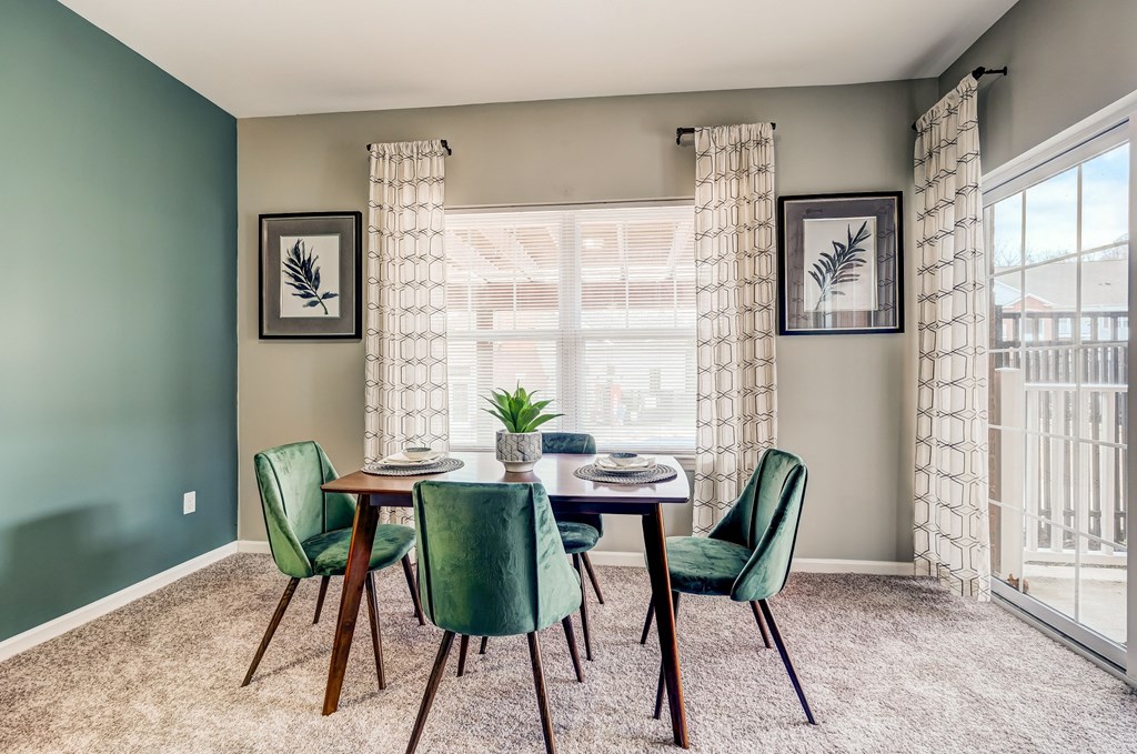 a dining room with a table and chairs and a window