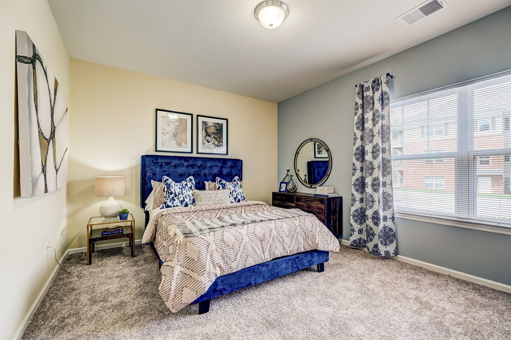 a bedroom with a bed and a large window
