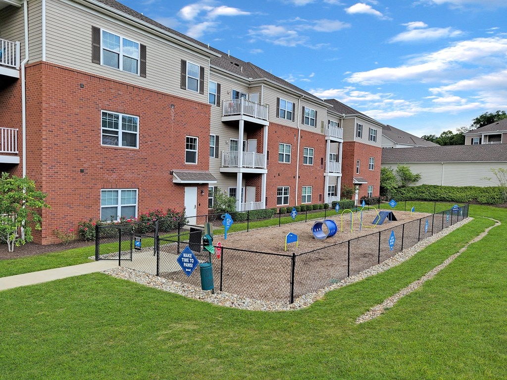 a fenced in playground in front of an apartment building