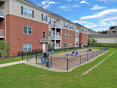 a fenced in playground in front of an apartment building