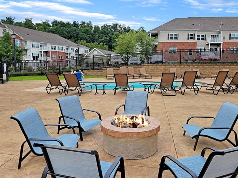 an outdoor patio with chairs and a fire pit