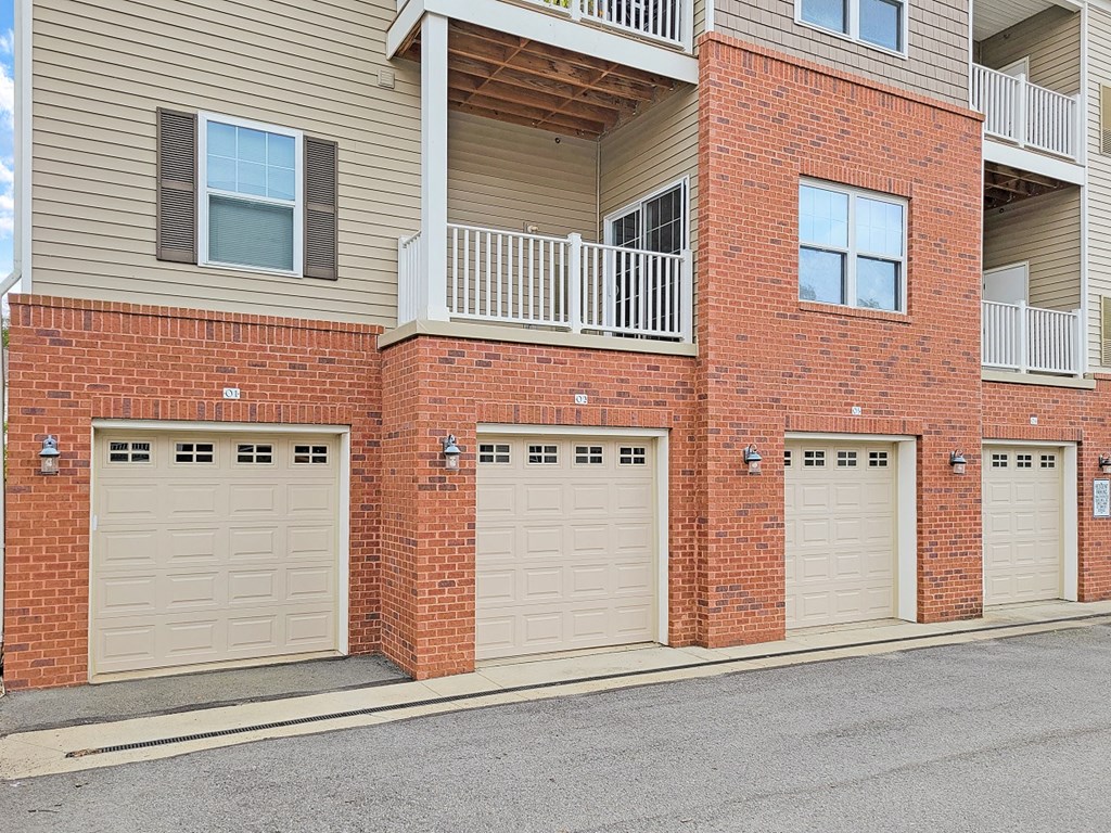 three garage doors on the side of a brick building