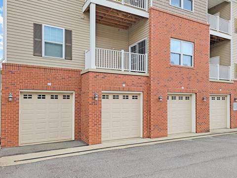 three garage doors on the side of a brick building