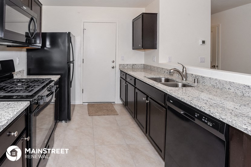 a kitchen with granite counter tops and black appliances