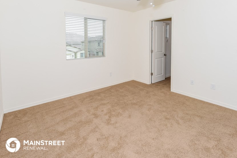 a bedroom with carpet and a door to a closet